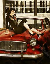 Pin-Up style model sitting on an Antique car