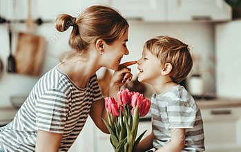 Happy mother`s day! child son gives flowers for  mother on holiday