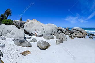 A young woman sittingon the boulders of clifton beach in the capetown area of south africa.4