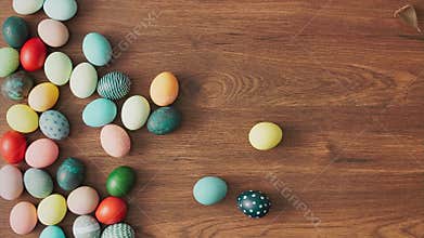 Hands Taking colorful Easter eggs of wooden table. Easter holiday decorations, Easter concept background