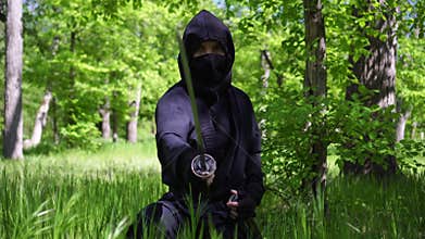 Portrait of a ninja man with a katana sword. Japanese ninja with a fighting sword in black clothes