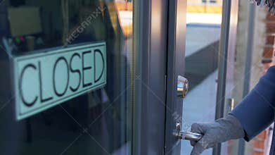 Woman in medical glove trying to open closed door