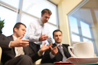 Young business men talking in an office -blur