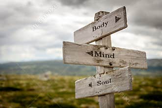 body mind soul text engraved on old wooden signpost outdoors in nature