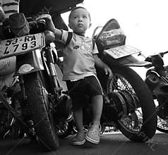 Kid grows up between the motorbikes in Hanoi