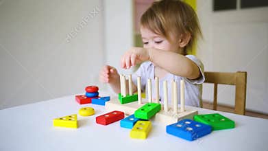 Baby plays in the constructor. small child builds a castle out of blocks. concept of development of fine motor skills