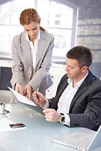 Good-looking boss signing contract at desk