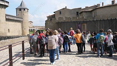 Exterior of Carcassone Castle tourists milling around.