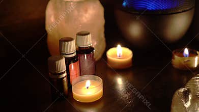 Aroma electric oil diffuser lamp, candles on wooden table in room. Aromatherapy, 4k
