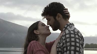 Romantic young loving couple kissing at the lake