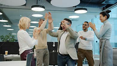 Happy people employees dancing at corporate party having fun clapping hands