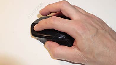 Man`s hand moves the mouse working on the computer