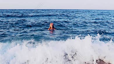 Girl swim in sea wave far from coast. Slow motion