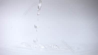 Pour water to water surface in container over white background.
