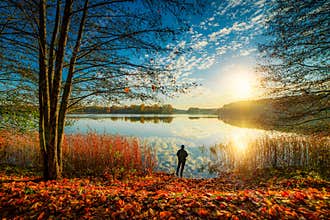 fishing in fall sunrise, forest lake and beautiful scenic fall nature