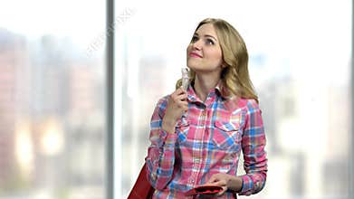 Dreamy woman holding money on blurred background.