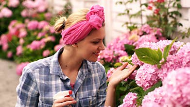 Countryside gardening. Woman watering plants in garden at home.