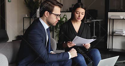 Focused male boss leader ceo listening to indian female colleague.