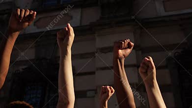 Clenched fists raised in the air. Violence protests, black lives matter, people chanting stop racism slogans