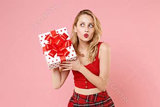 Amazed young woman in red sexy clothes isolated on pastel pink background. St. Valentine`s Day International Women`s Day