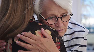 Young woman embracing an elderly lady. Grief and bead news, empathy concept