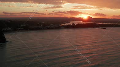 Sunset seen from a drone in Australia Noosa Beach at the coast line with moody clouds and brutal red light from the sun