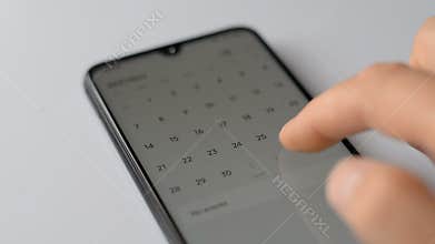 Man using calendar app on the mobile device closeup