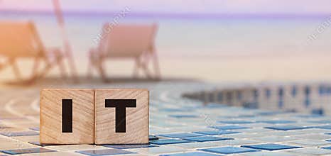 IT letters on Wooden Cubes on swimming pool borders. business concept