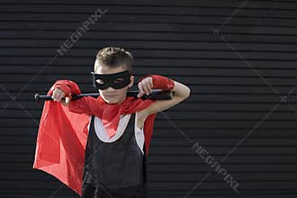 Boy wearing Zorro costume with baseball bat