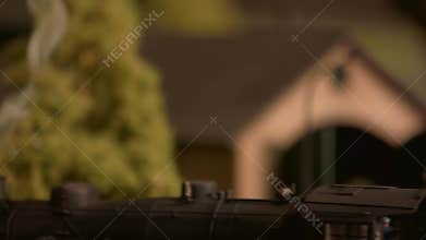 Model train with steam on blur station background.