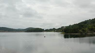 Flight over a large lake with a man kayaking over the lake