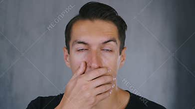 Shocked and surprised man takes off his glasses and looks at the camera in surprise.