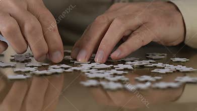 Aged man trying to combine puzzle, rehabilitation, thought process support