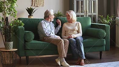 Senior older family couple having trust conversation sitting on sofa