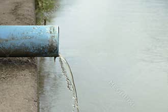 The sewer that water is flowing from the end of the pipe.