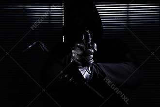 Burglary and robbery. skillful professional masked burglar aim the gun and crowbar and breaking into the house, hand close up on