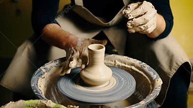 Potter modelling ceramic pot from clay on a potter's wheel. Workshop, art concept