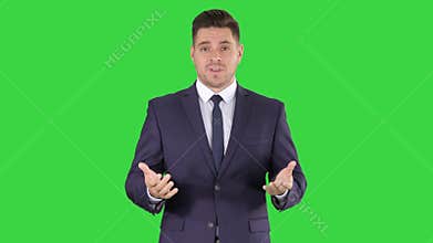 Handsome businessman looking in camera and talking on a Green Screen, Chroma Key.