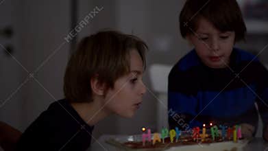Happy kids blowing candles at anniversary
