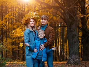Happy Parents with a child on a walk in the fall. Family