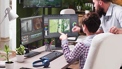 In post production office female colorist talking with senior editor