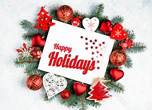 Happy Holidays Text with Holiday Evergreen Branches and photoframe New Year tree, red decorations Top view, flat lay