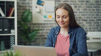 Portrait of pretty office working using laptop typing smiling looking at camera