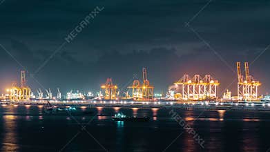 Time-lapse of cranes loading shipment containers in cargo shipping port at night. Import or export business, logistic industry
