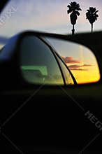 Sunset clouds reflected car mirror