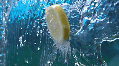 Slice of lemon falling in water waterfall cascade with splash in high speed shot at 1500 fps