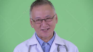 Face of happy mature Japanese man doctor nodding head yes