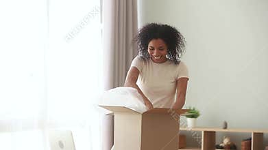 Happy excited african american woman customer open parcel at home