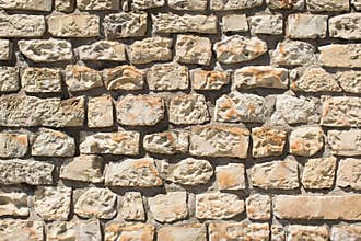 Stone wall background closeup light sun
