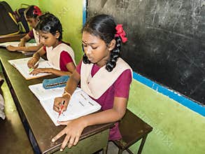 Portrait of children friends classmates studying with book sitting on chairs indoors at the school. School kids enjoying